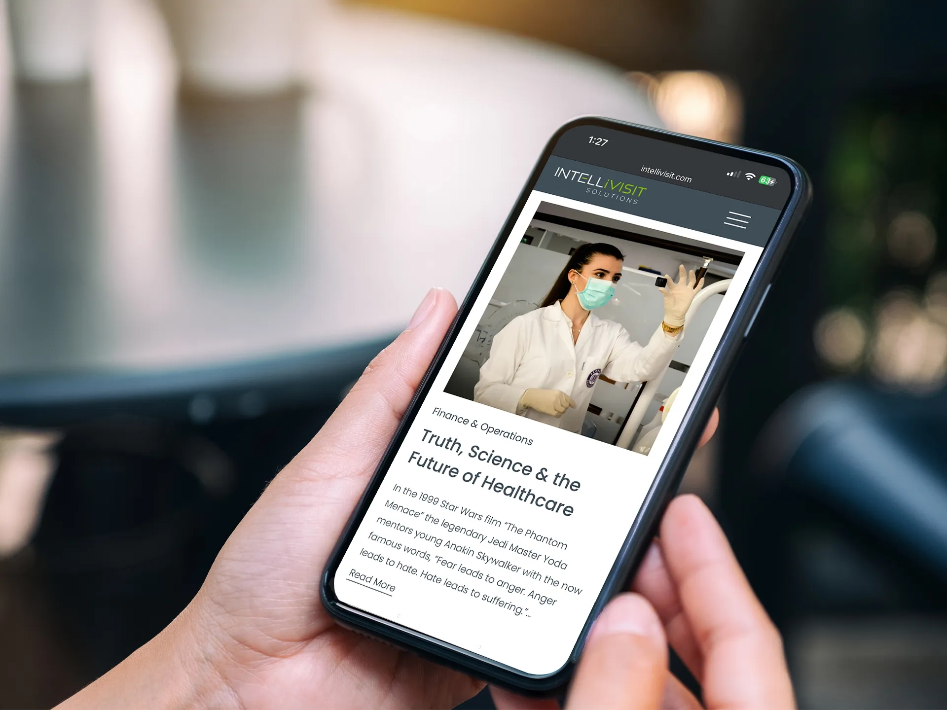 Person holding a smartphone displaying an Intellivisit blog article titled ‘Truth, Science & the Future of Healthcare,’ part of the mobile-optimized website designed by LXE Digital