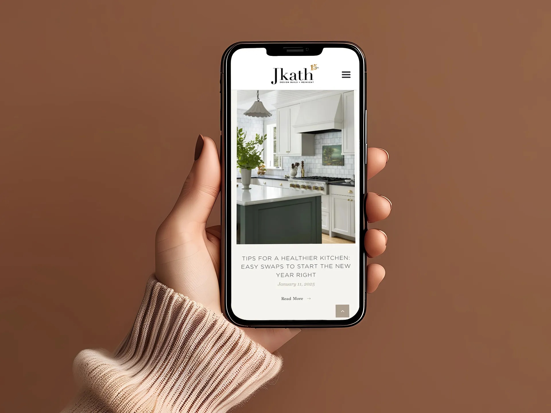 Hand holding a smartphone displaying a blog article on the Jkath website, showcasing the mobile-optimized design and editorial layout developed by LXE Digital