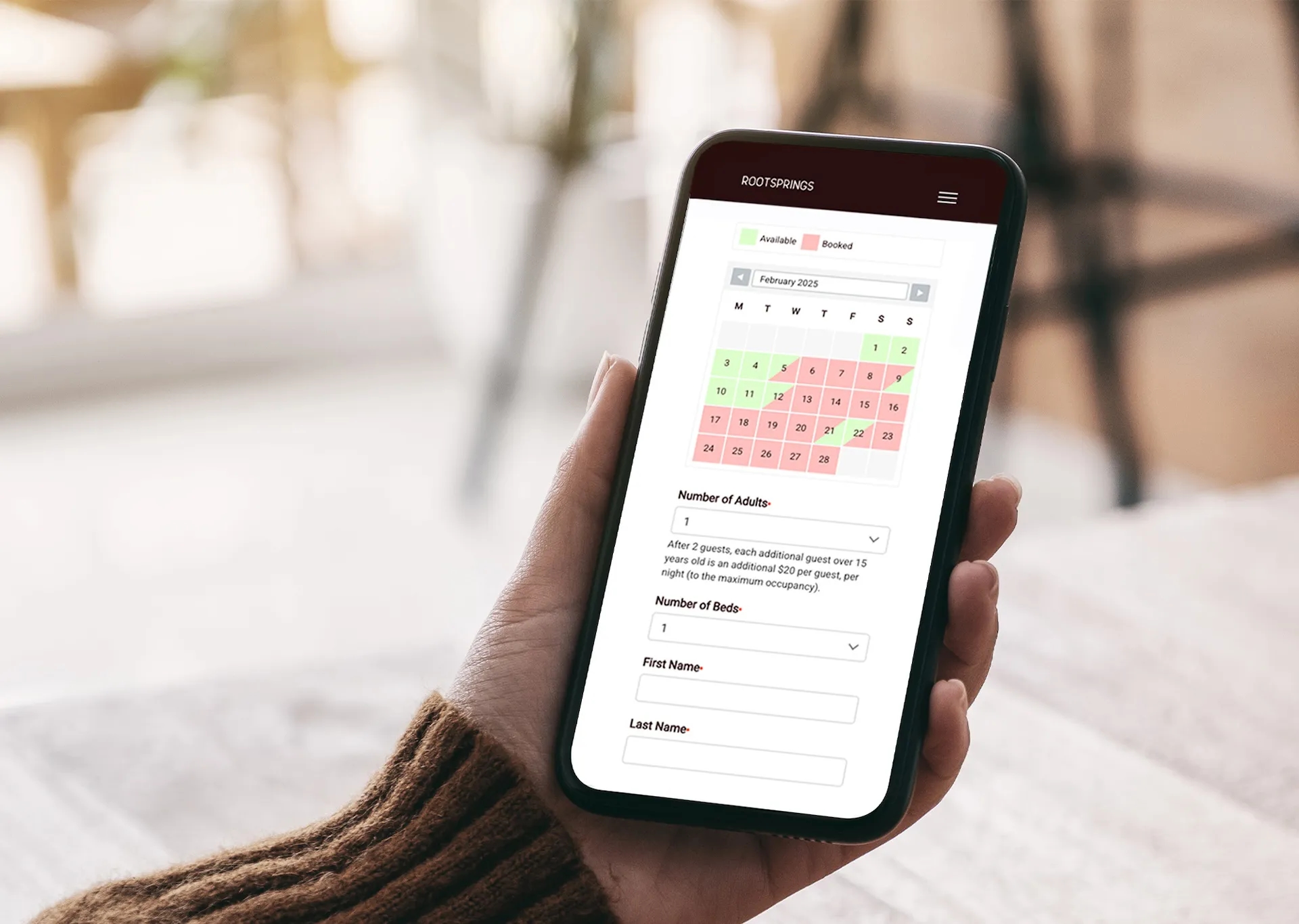 Person holding a phone showing the Rootsprings online booking calendar, part of the custom retreat center website developed by LXE Digital