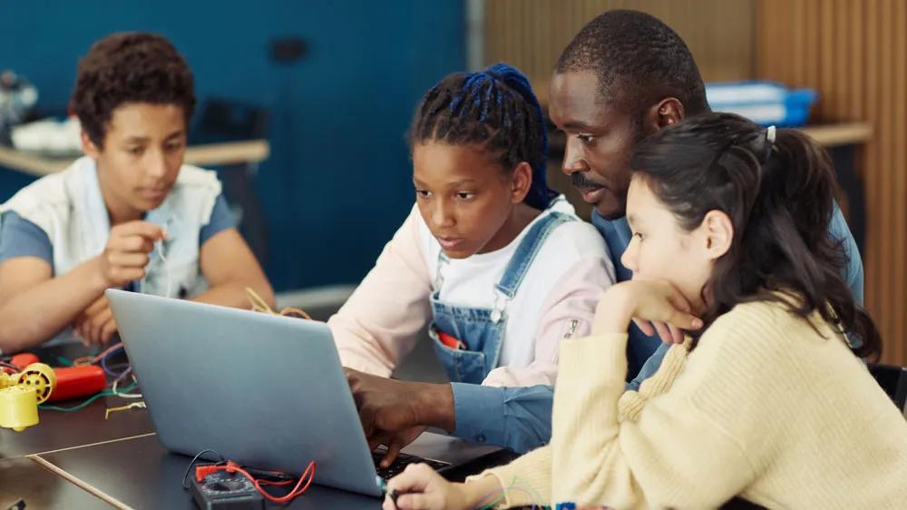 LXE Digital team member leading a Fix-It Own It workshop with middle school students, teaching them how to upgrade and test their own computers in partnership with American Family Insurance